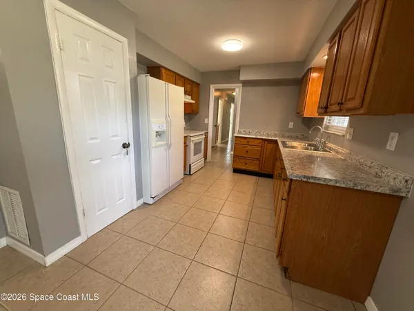 a kitchen with granite countertop a sink a stove and a refrigerator