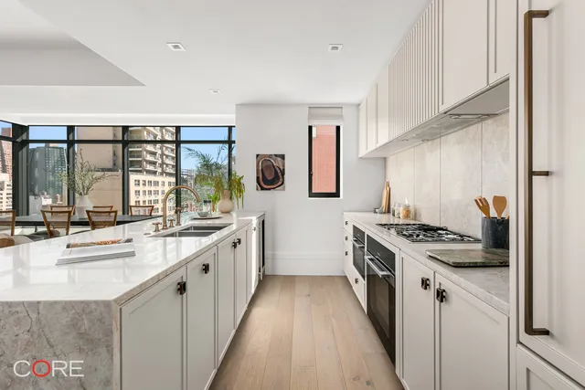 a kitchen with stainless steel appliances granite countertop a table and chairs in it