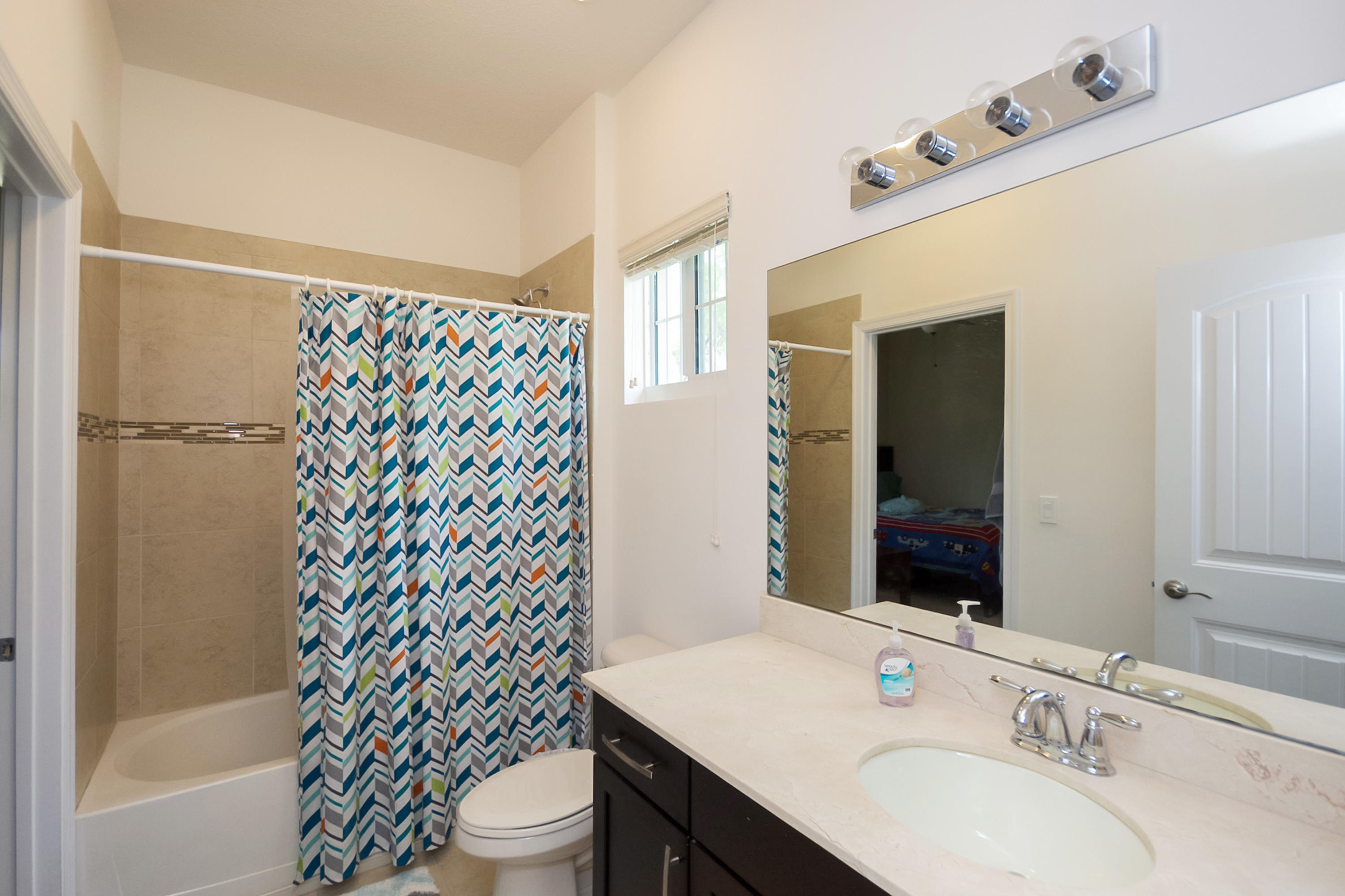 2622 Webb Avenue Delray Beach, FL 33444 - Photo 11 of 16 a bathroom with a sink a toilet and shower curtain