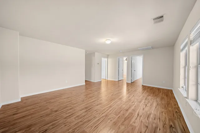 a view of a room with wooden floor and a ceiling fan