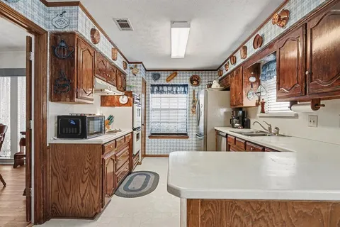 a kitchen with stainless steel appliances granite countertop a refrigerator and a sink