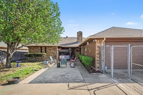 a view of a brick house with wooden fence next to a yard