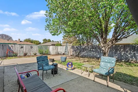 a view of house with backyard and sitting area