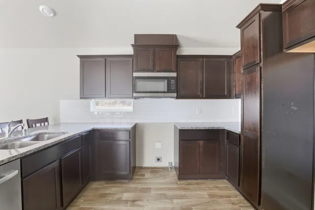 a kitchen with stainless steel appliances granite countertop a sink stove and refrigerator