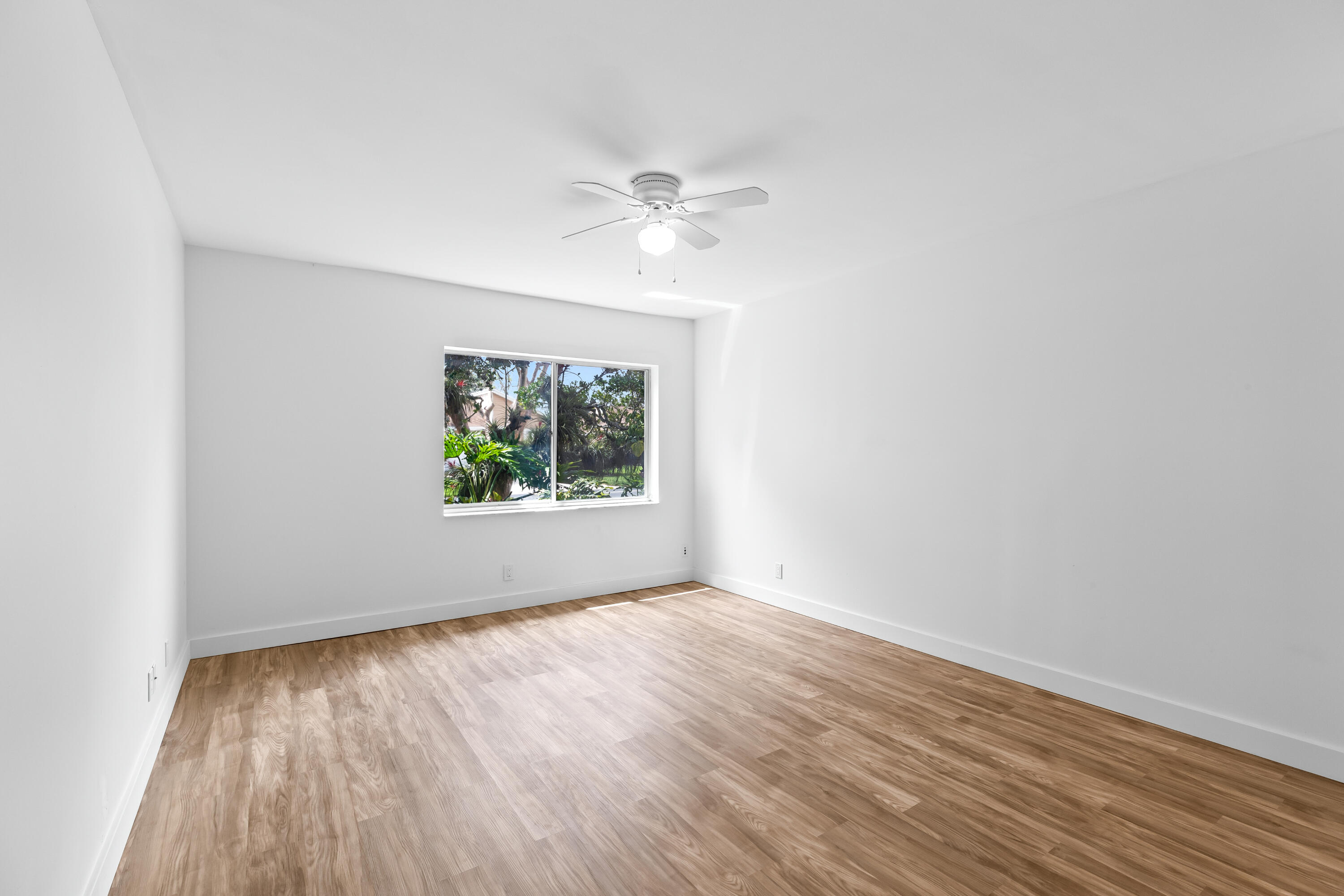 8089 Springtree Road Boca Raton, FL 33496 - Photo 12 of 35 an empty room with wooden floor and windows