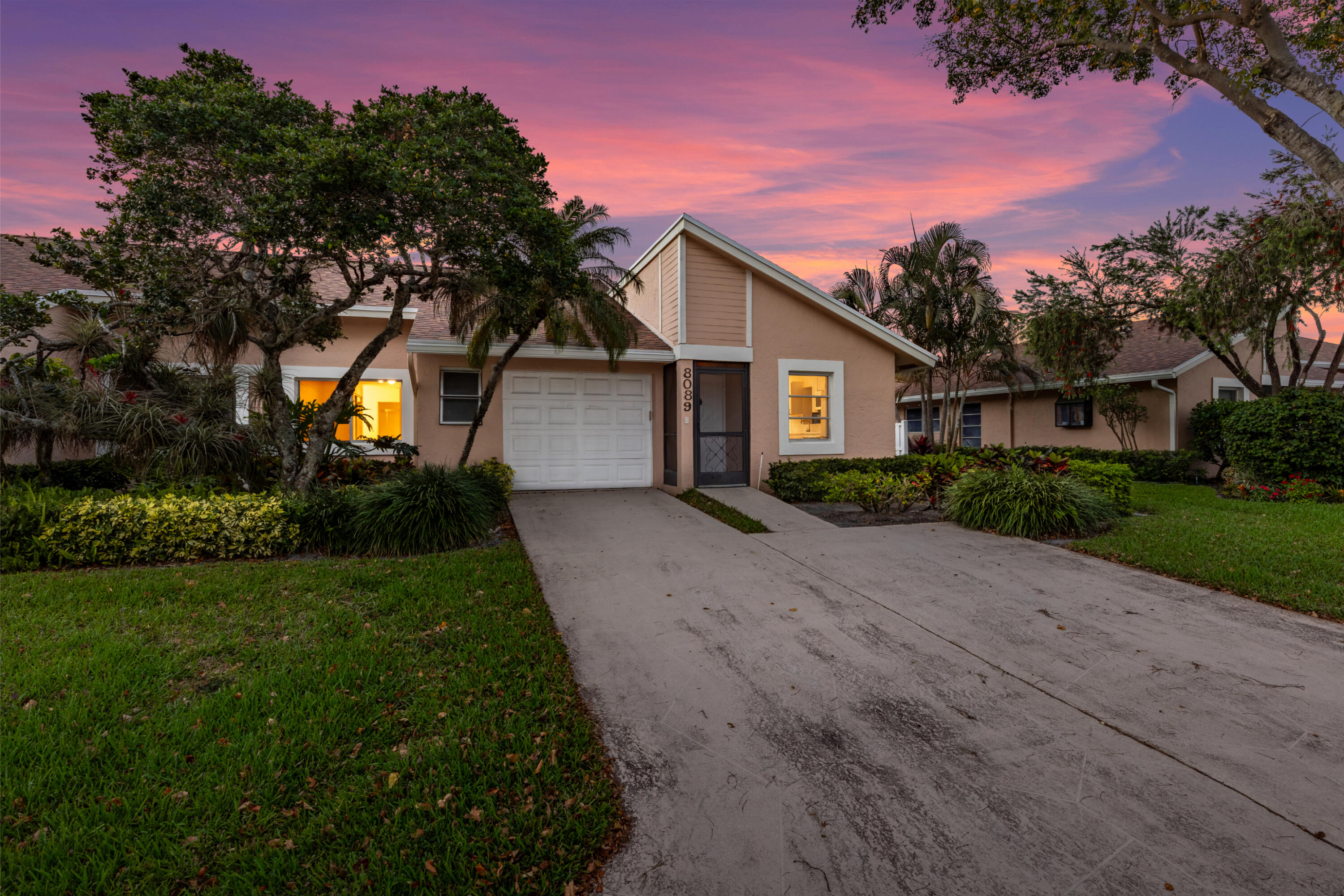 8089 Springtree Road Boca Raton, FL 33496 - Photo 22 of 35 a front view of a house with a garden and yard