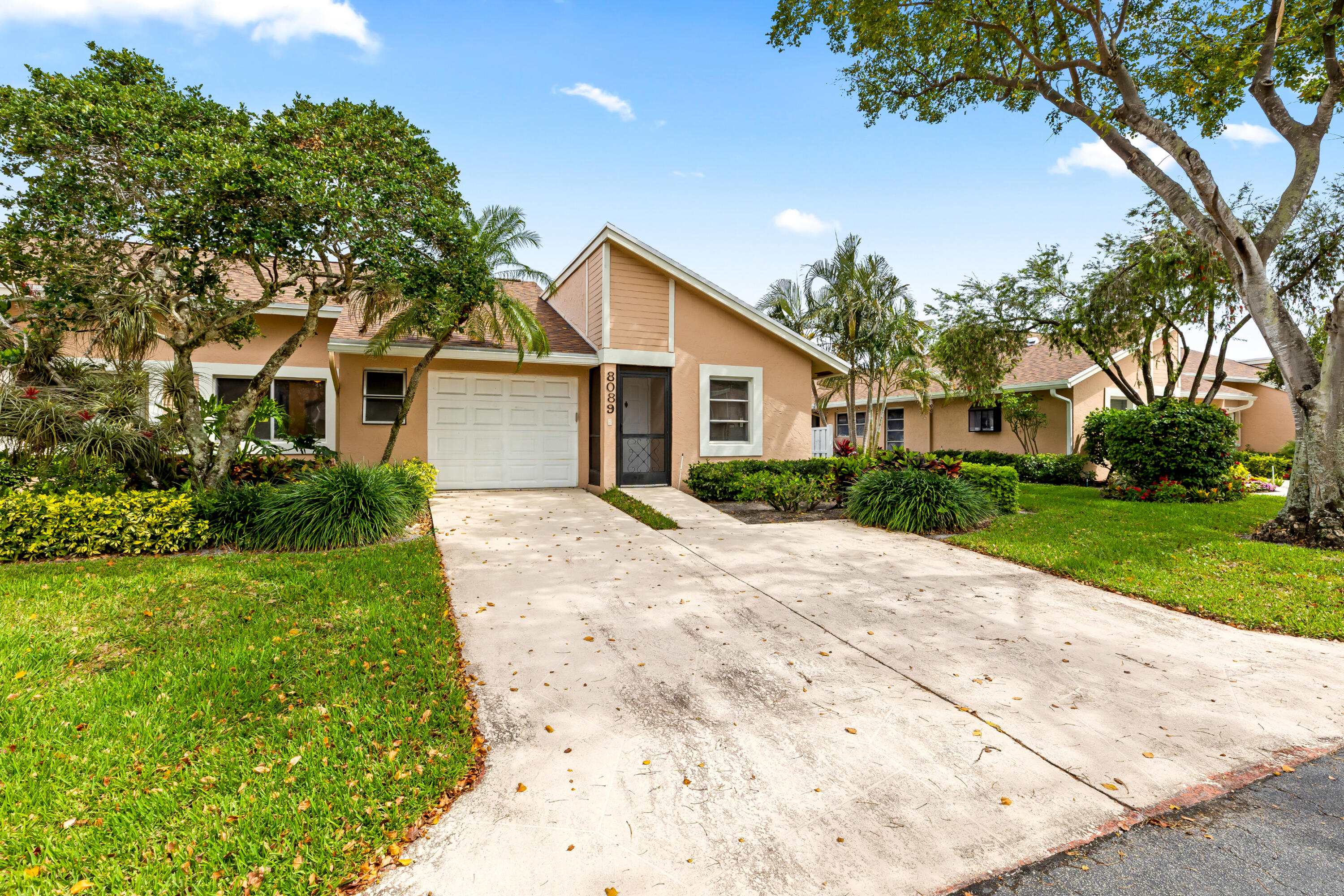 8089 Springtree Road Boca Raton, FL 33496 - Photo 25 of 35 a front view of a house with a garden