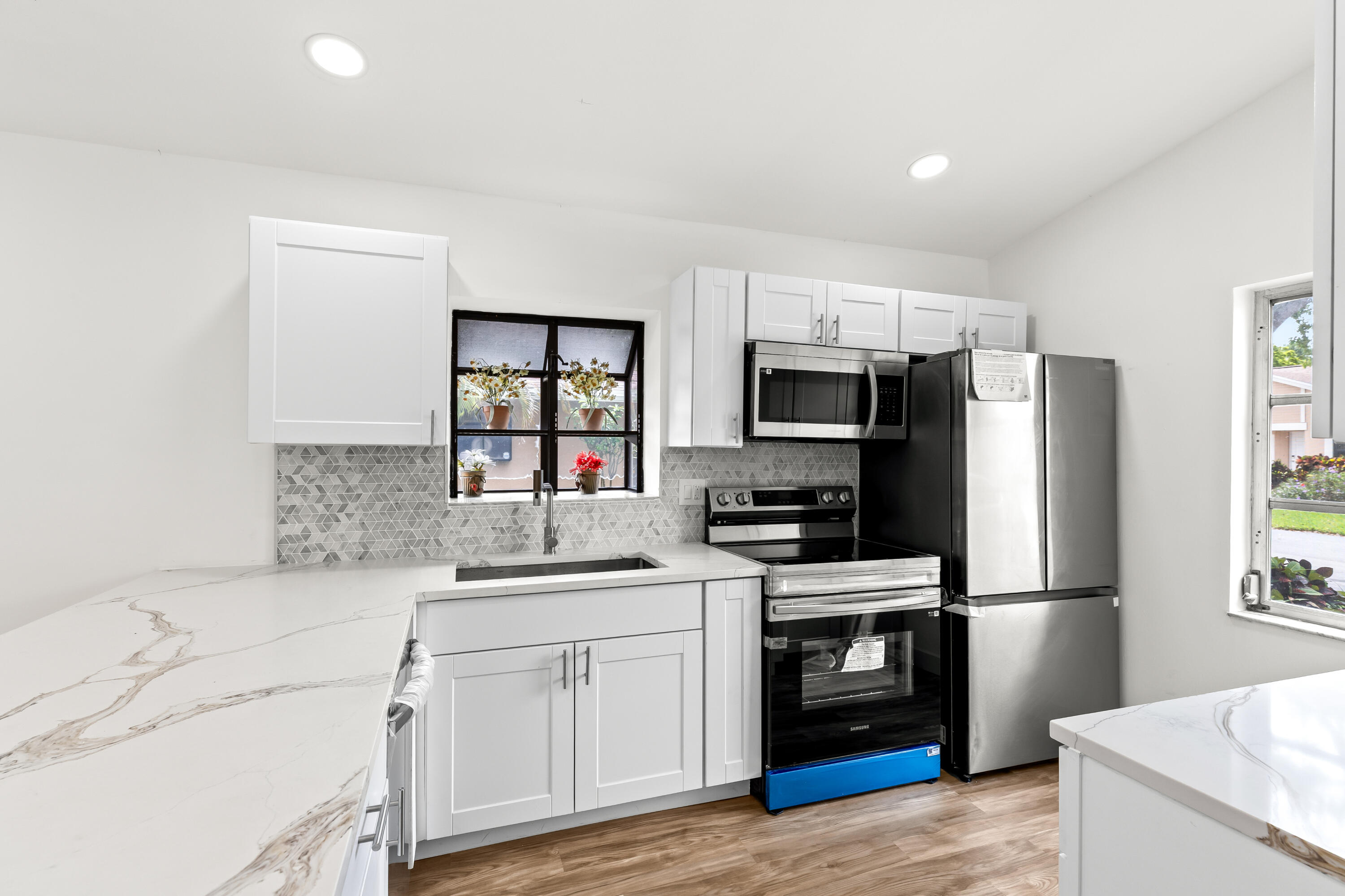 8089 Springtree Road Boca Raton, FL 33496 - Photo 3 of 35 a kitchen with a sink cabinets and stainless steel appliances