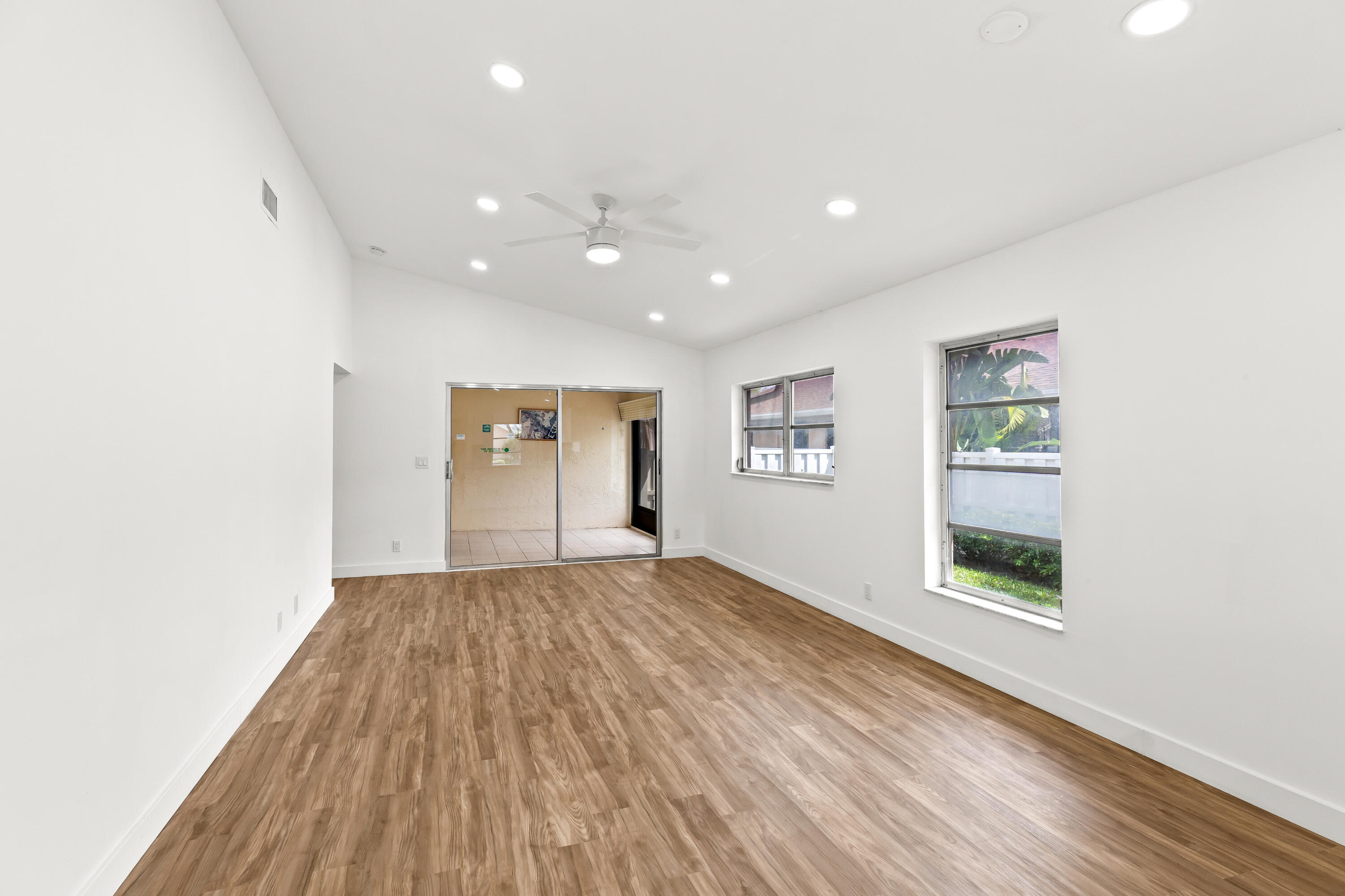 8089 Springtree Road Boca Raton, FL 33496 - Photo 5 of 35 a view of an empty room with a window and wooden floor