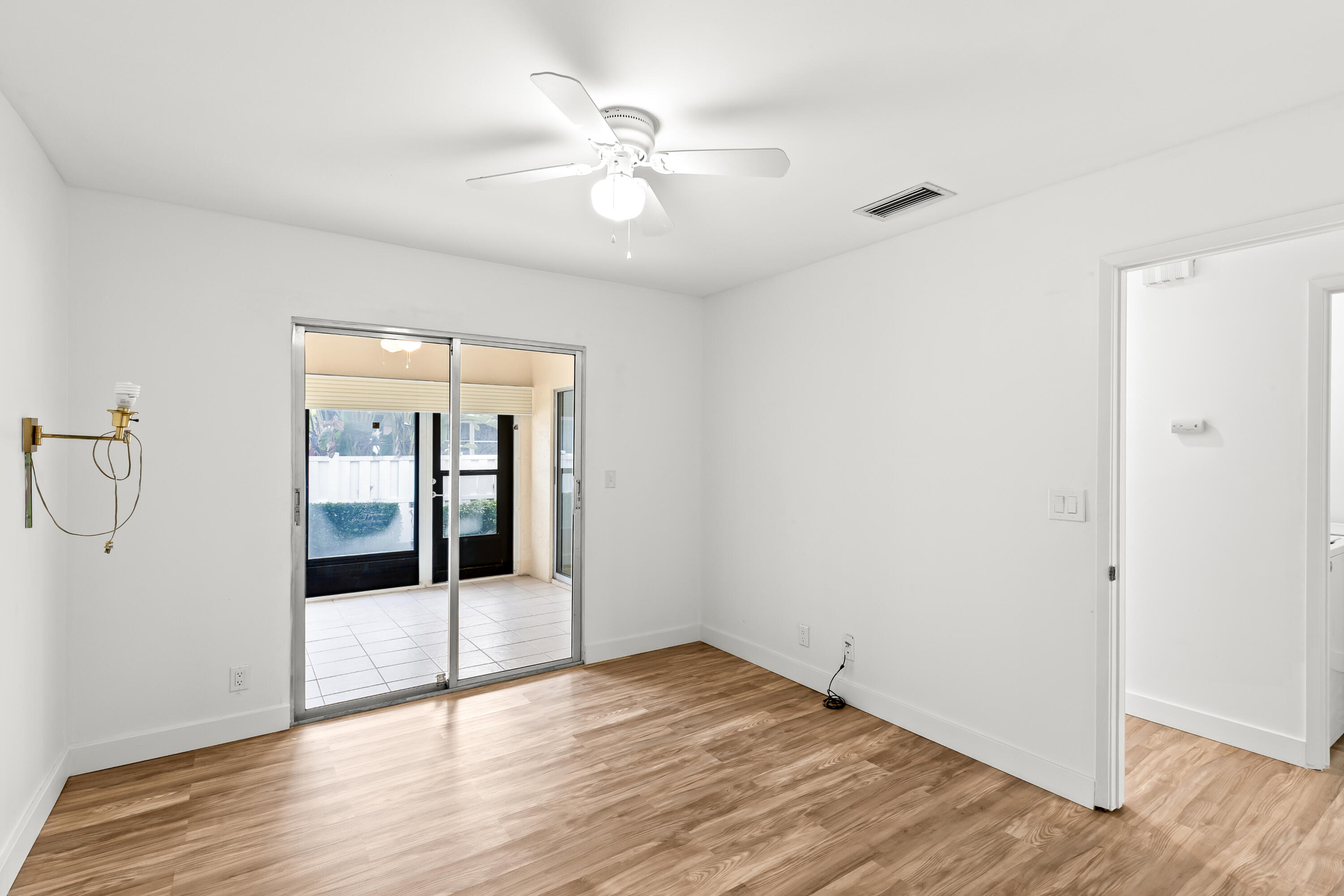 8089 Springtree Road Boca Raton, FL 33496 - Photo 9 of 35 an empty room with wooden floor and mirror