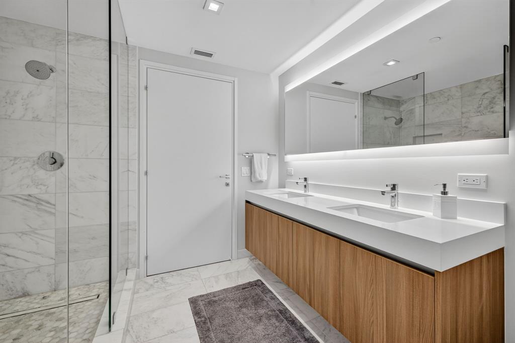 401 North Birch Road, Unit 1103 Fort Lauderdale, FL 33304 - Photo 28 of 45 a bathroom with a double vanity sink mirror and shower