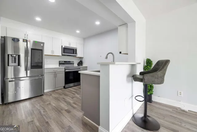 a kitchen with stainless steel appliances a refrigerator a sink a stove and cabinets