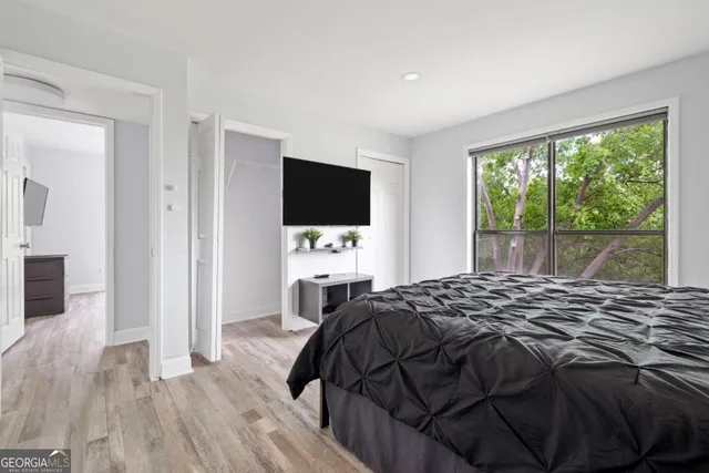 a bedroom with a bed and a flat tv screen on the dresser