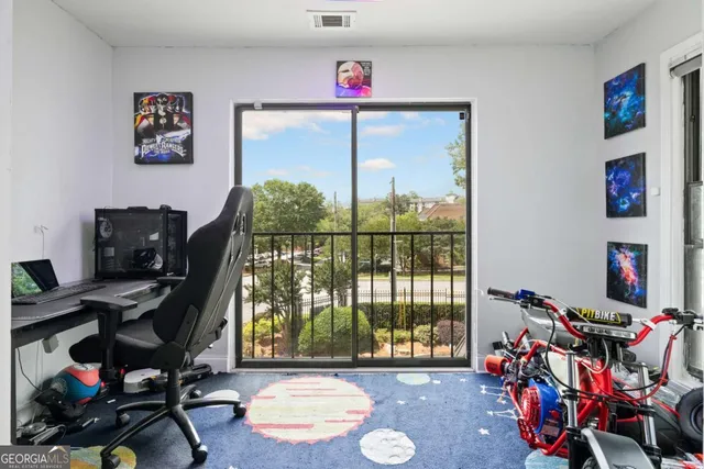 a view of a workspace with furniture and a window