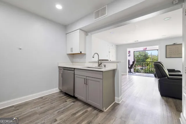 a kitchen with a sink a counter top space and living room area
