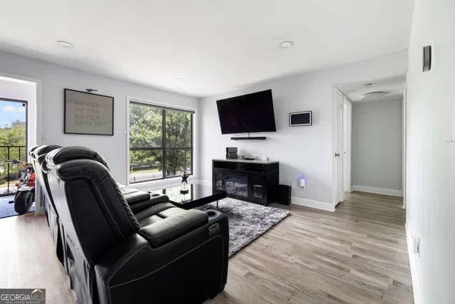 a living room with furniture a flat screen tv and a fireplace
