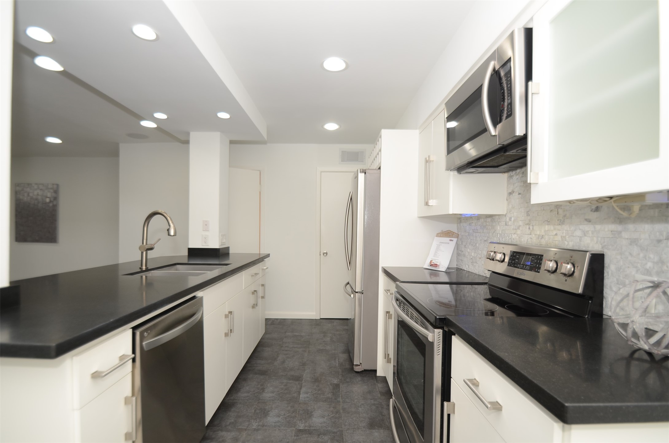 5524 Beverly Hill Street, Unit 2 Houston, TX 77056 - Photo 1 of 43 a kitchen with granite countertop a sink stainless steel appliances and cabinets