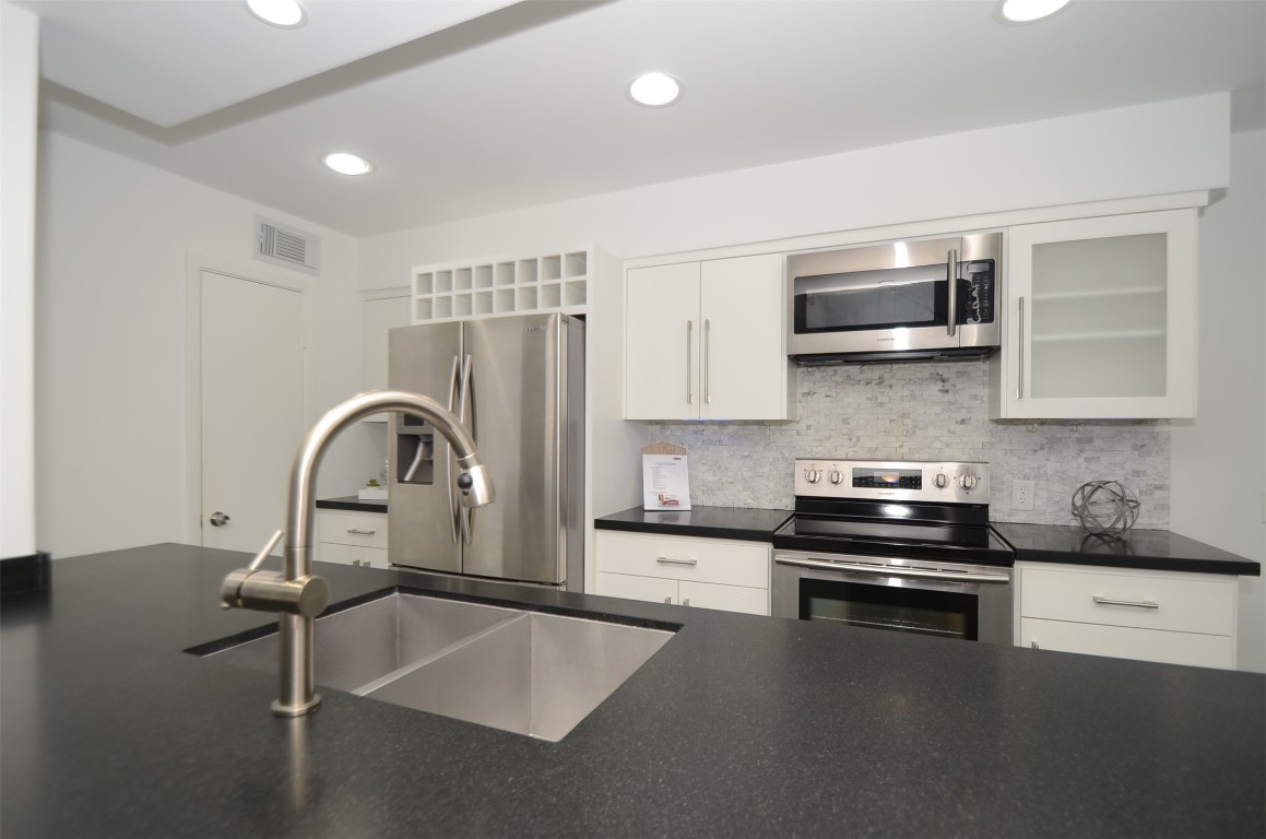 5524 Beverly Hill Street, Unit 2 Houston, TX 77056 - Photo 4 of 43 a kitchen with stainless steel appliances kitchen island a stove a sink and a microwave