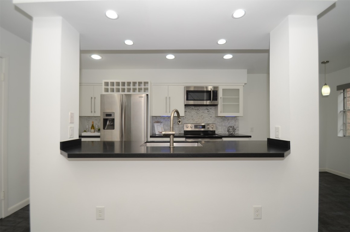 5524 Beverly Hill Street, Unit 2 Houston, TX 77056 - Photo 5 of 43 a kitchen with kitchen island granite countertop a stove and a refrigerator