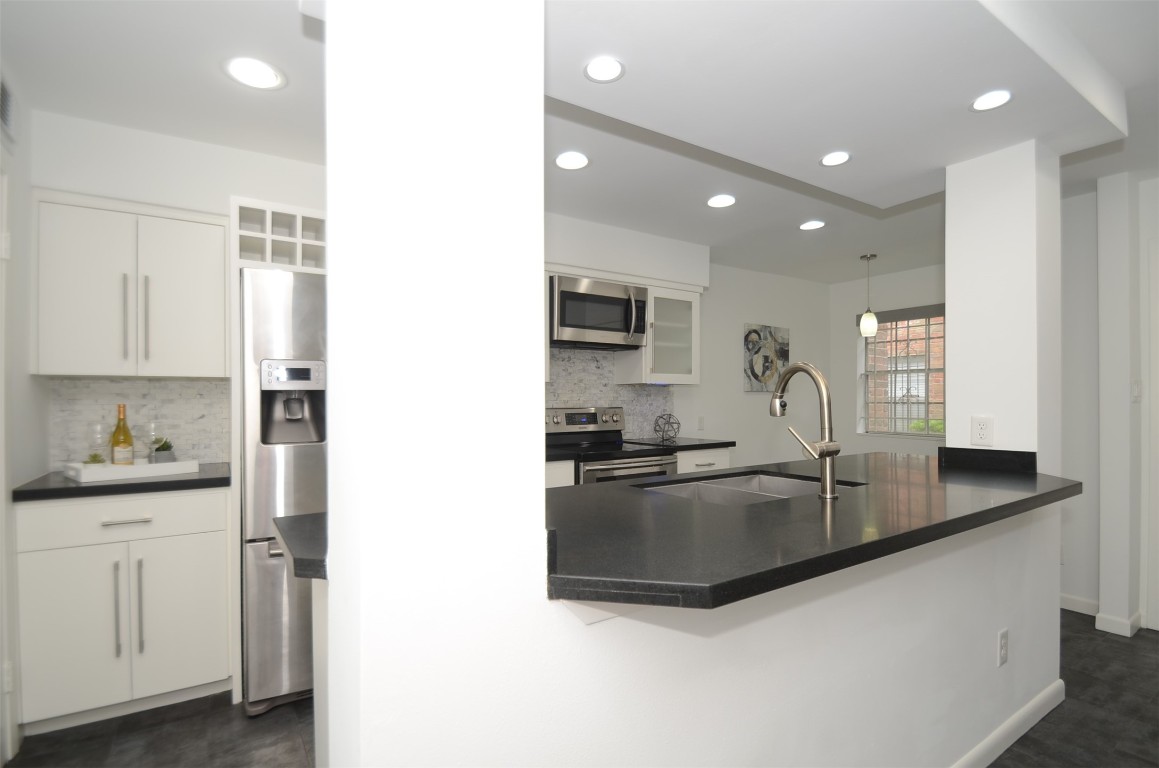 5524 Beverly Hill Street, Unit 2 Houston, TX 77056 - Photo 6 of 43 a kitchen with granite countertop a sink and white cabinets