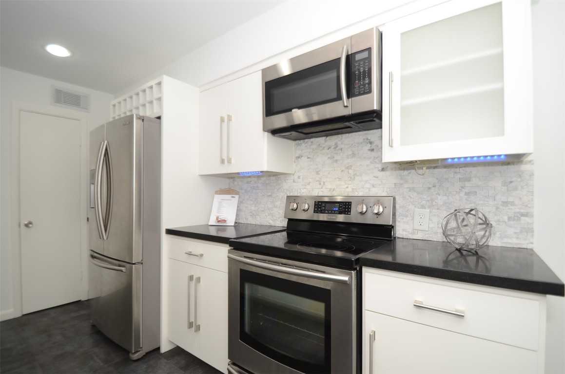 5524 Beverly Hill Street, Unit 2 Houston, TX 77056 - Photo 9 of 43 a kitchen with stainless steel appliances a stove microwave and sink