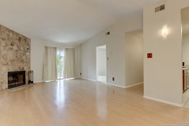wooden floor in an empty room with a fireplace