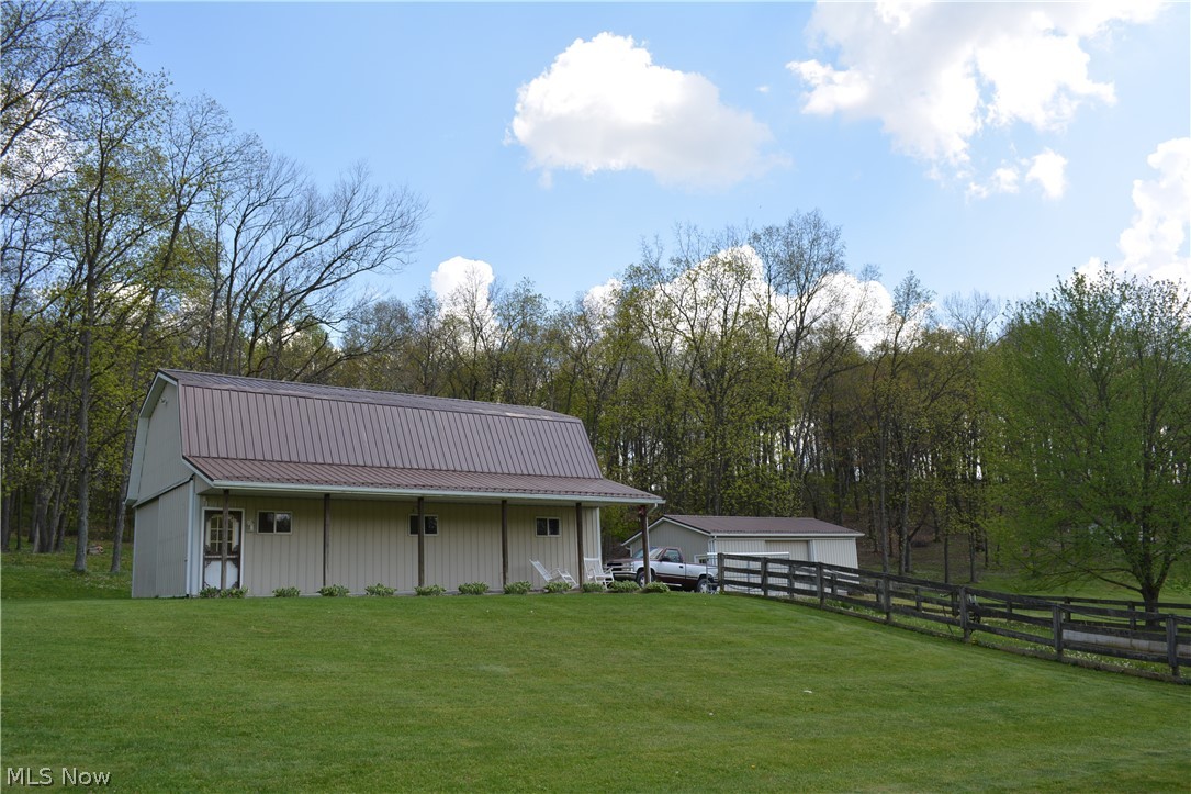 2363 Tabor Ridge Road Northeast New Philadelphia, OH 44663 - Photo 9 of 42 Expansive green lawn featuring a large barn with a metal roof and a detached garage