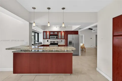 a large kitchen with kitchen island a large counter space a sink appliances and cabinets