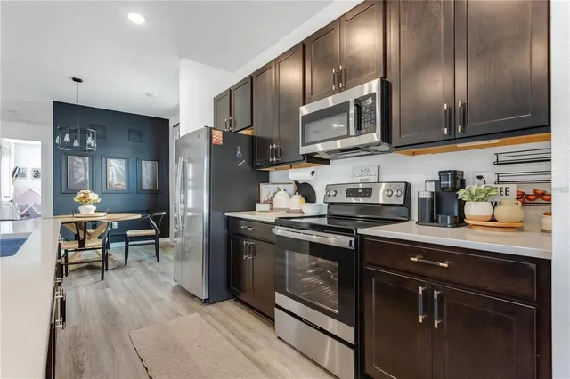 a kitchen with stainless steel appliances granite countertop a stove refrigerator sink and cabinets