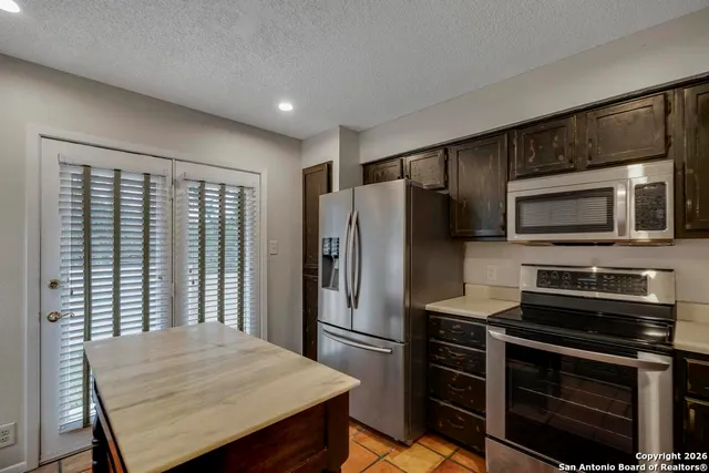 a kitchen with a refrigerator microwave and stove top oven