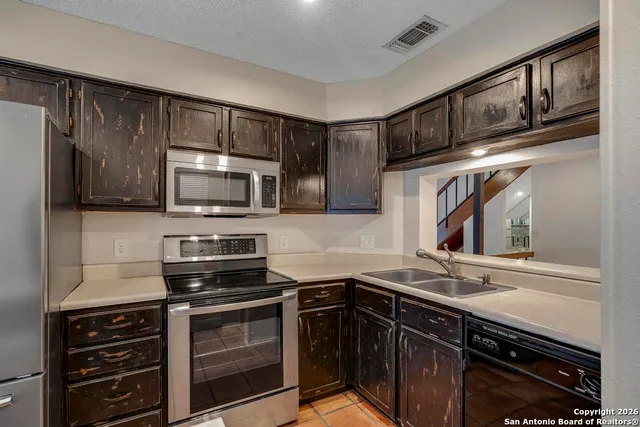 a kitchen with stainless steel appliances a stove sink microwave and cabinets