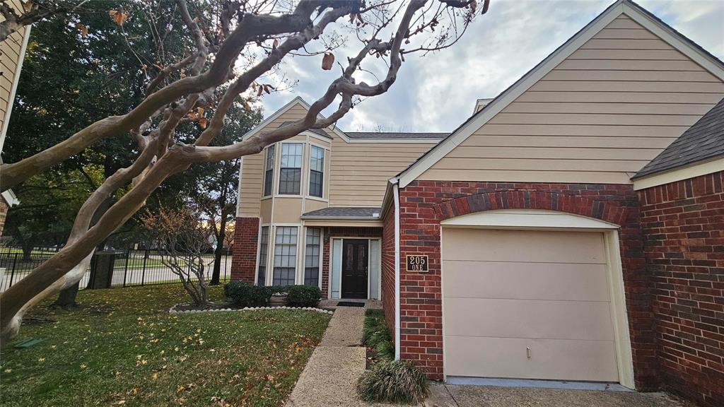 205 Cimarron Trail, Unit 1 Irving, TX 75063 - Photo 1 of 1 a front view of a house with a tree