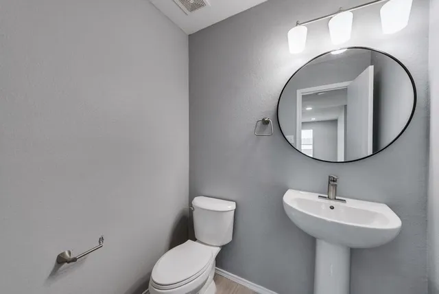 a bathroom with a toilet sink and mirror