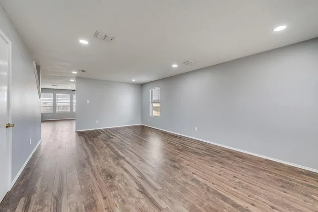 a view of empty room with wooden floor