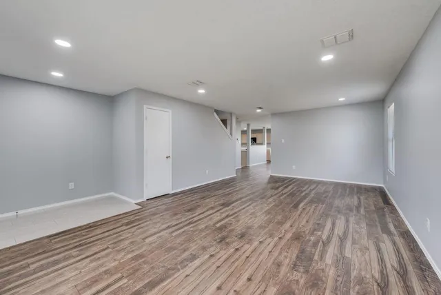 a view of an empty room with wooden floor