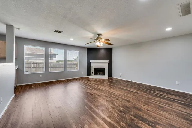 a view of an empty room with a fireplace and a window
