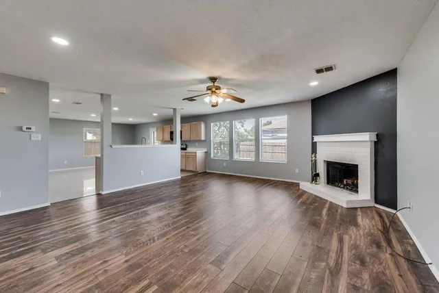 a view of an empty room with a fireplace and a window