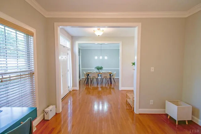 a dining room with furniture potted plants and wooden floor