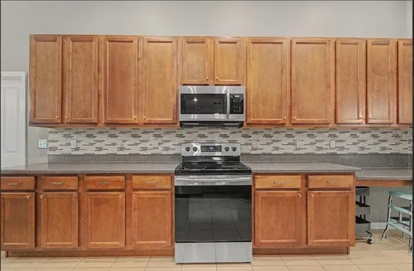 a kitchen with stainless steel appliances granite countertop a refrigerator a sink a stove top oven and a dishwasher