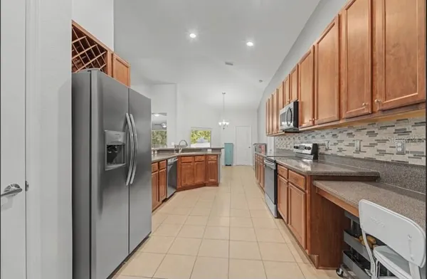 a large kitchen with stainless steel appliances granite countertop a stove a sink a dining table and chairs