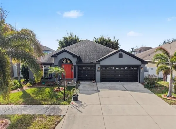 a front view of house with yard and trees in the background