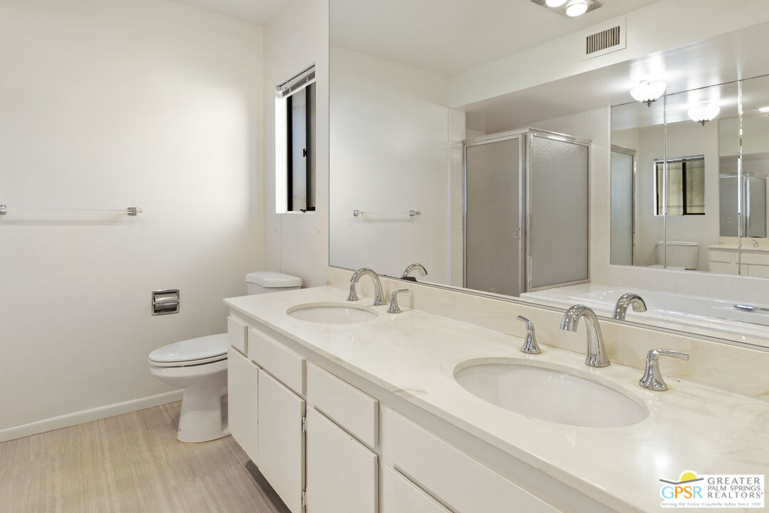2296 Paseo Del Rey Palm Springs, CA 92264 - Photo 17 of 42 a bathroom with a toilet a sink a mirror and vanity