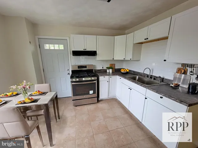 a kitchen with stainless steel appliances a stove a sink a microwave and cabinets