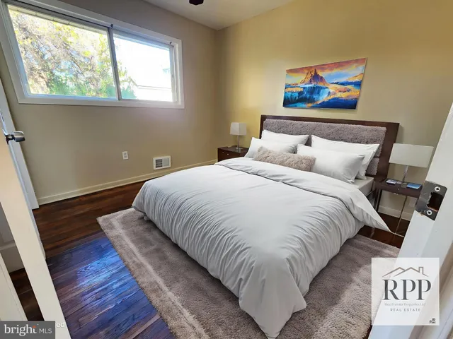 a large bed sitting in a bedroom next to a window