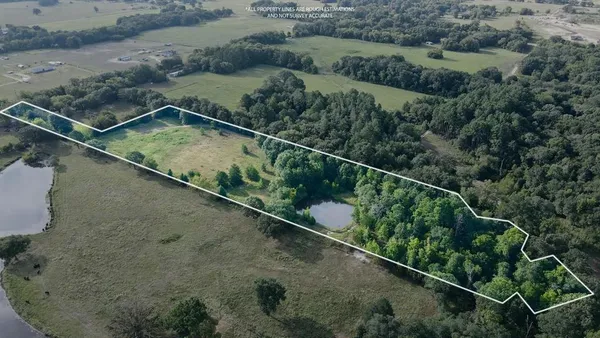 an aerial view of a house with a yard and lake view