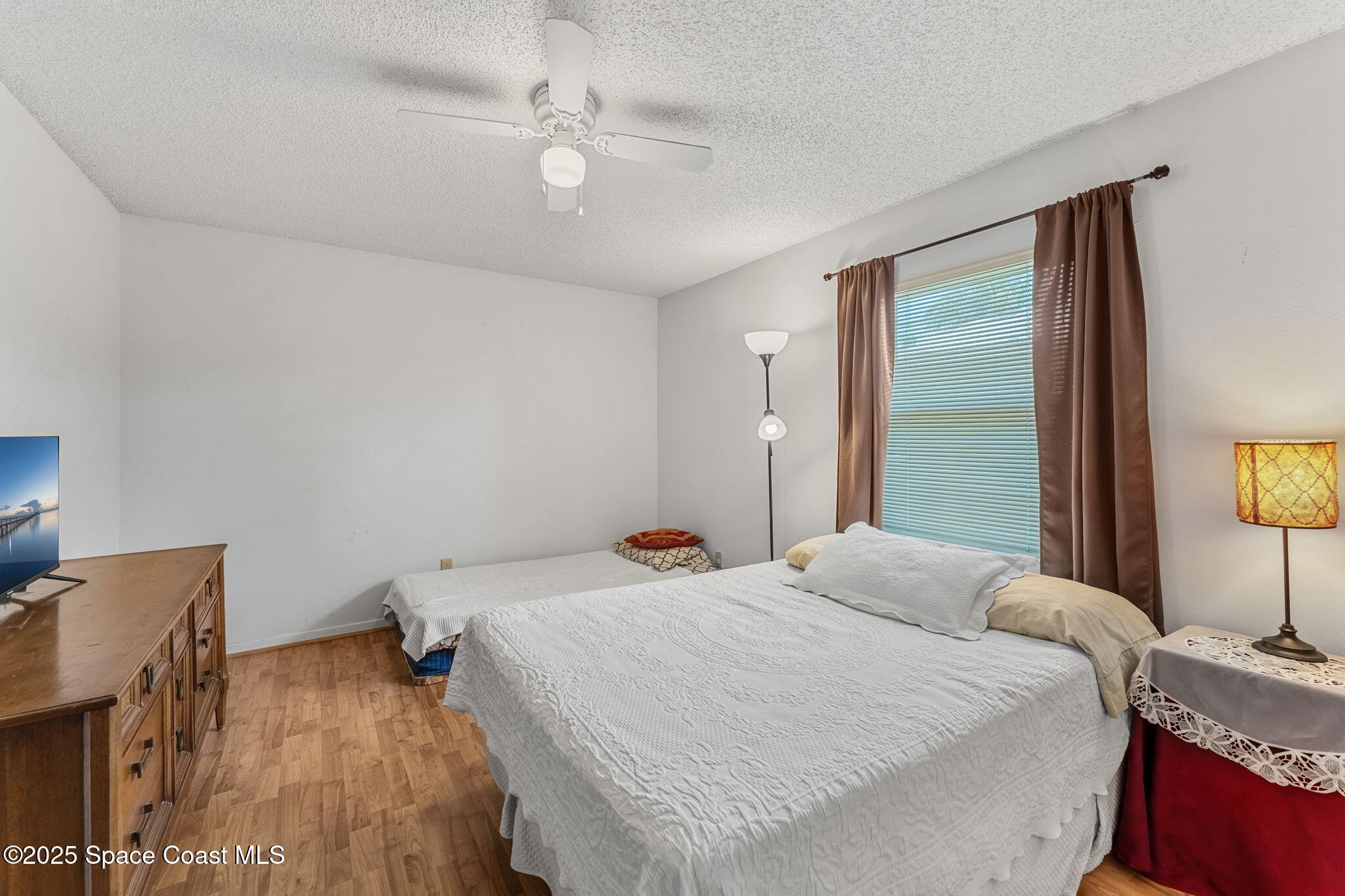 440 Pine Tree Drive Indialantic, FL 32903 - Photo 17 of 34 a bedroom with a bed and a chandelier