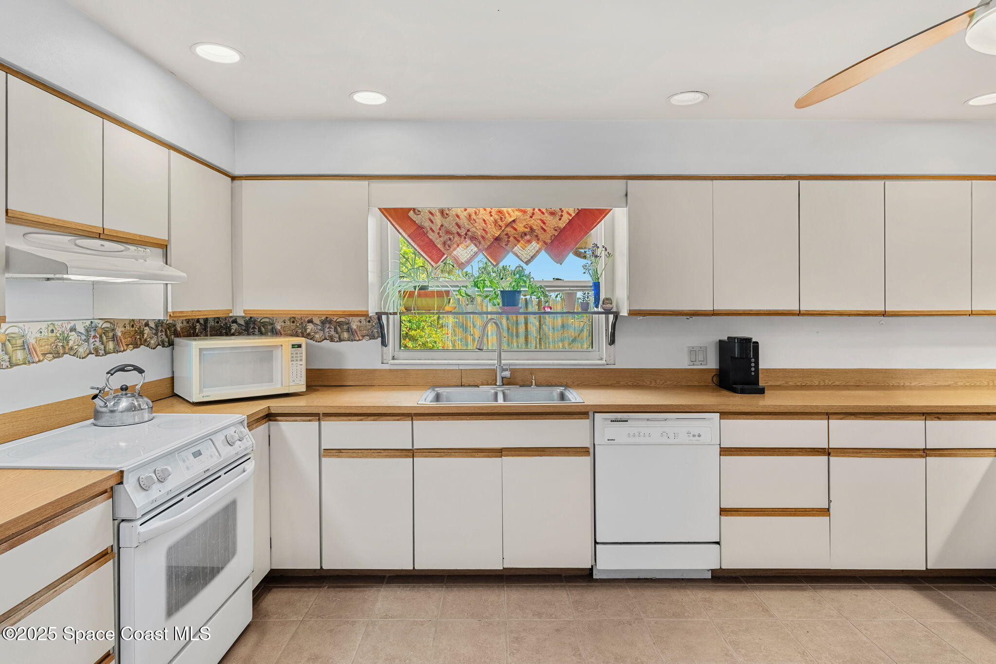 440 Pine Tree Drive Indialantic, FL 32903 - Photo 10 of 34 a kitchen with stainless steel appliances granite countertop a sink and cabinets with wooden floor