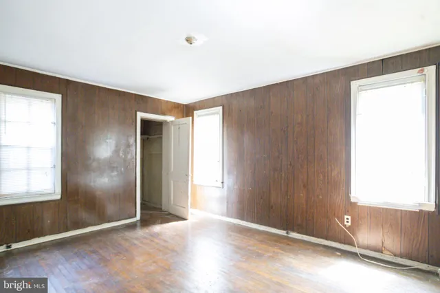 an empty room with windows and closet