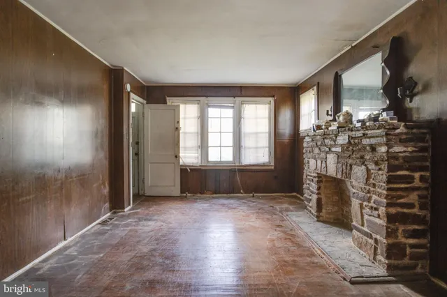 a view of empty room with a fireplace and windows