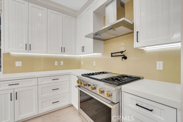 a kitchen with a stove oven and wooden floor
